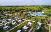 Vista aerea di Camping Village Roma Capitol con bungalow, grande piscina e pini nella Toscana, Italia.