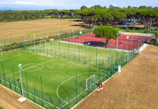 Luftfoto af sportsbaner på Camping Village Roma Capitol i Toscana, Italien, omgivet af natur.