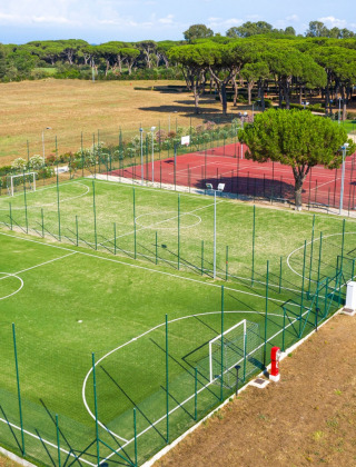 Vista aérea de campos deportivos en Camping Village Roma Capitol en la Toscana, Italia, entre naturaleza.