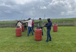 Groep mensen doet aan boogschieten op Camping de Speld, een vakantiepark in Zuid-Holland, Nederland.