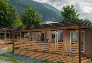 Foto de cabañas glamping en un parque vacacional, rodeado de montañas y árboles, ideal para relajarse.