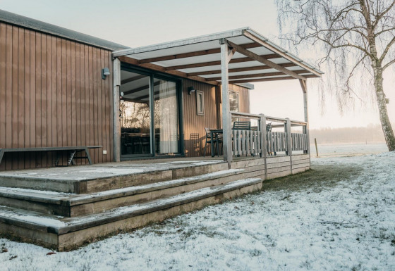 Cabaña familiar de madera con terraza cubierta y nieve, Family Lodge, Holiday park De Boshoek, Países Bajos.
