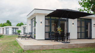 Lodge moderno Villa Maritiem con terraza de madera y muebles de exterior en MarinaPark Bad Nederrijn, Países Bajos.