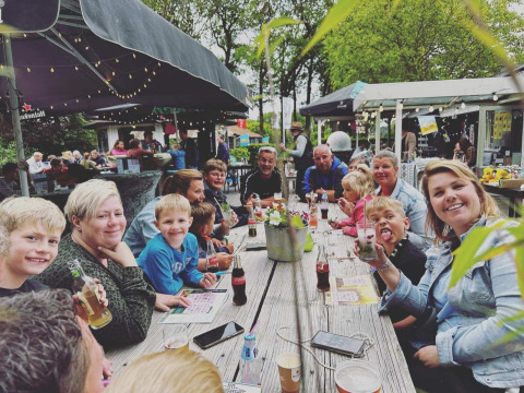 Gruppo di persone che mangia insieme all'aperto al Camping Emmen, parco vacanze a Drenthe, Paesi Bassi.