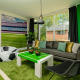 Stue i fodboldtema på FC Mölke Stadion Lodge i Holiday Park Mölke, Holland, med grønne vægge og dekorationer.