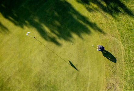 Foto aérea de un golfista en el green cerca de Schoonebeek, Drenthe, Países Bajos, con largas sombras.