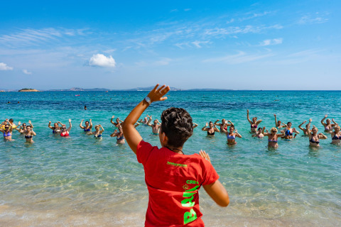Un istruttore guida un gruppo in una lezione di acquagym in mare al Centro Vacanze Isuledda, Sardegna.