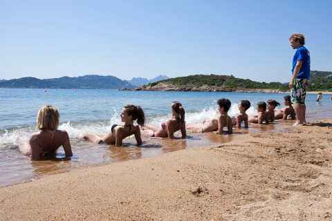 Kinderen ontspannen bij het water op het strand van Centro Vacanze Isuledda vakantiepark, Sardinië, Italië.