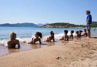 Kinderen ontspannen bij het water op het strand van Centro Vacanze Isuledda vakantiepark, Sardinië, Italië.