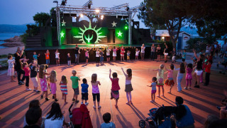 Niños bailan y juegan en el escenario del parque vacacional Centro Vacanze Isuledda en Cerdeña, Italia.