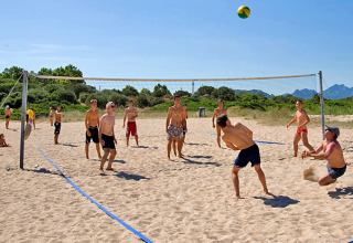 Jongeren spelen beachvolleybal in het zand aan het Centro Vacanze Isuledda vakantiedomein op Sardinië, Italië.