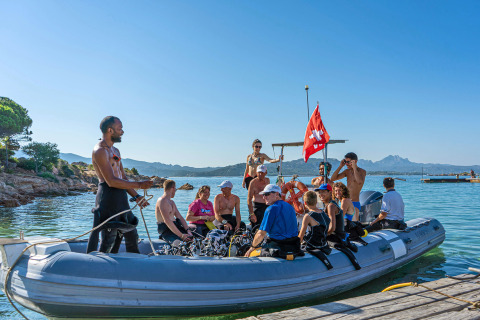 Group of people on an inflatable boat at Centro Vacanze Isuledda, Sardinia, Italy, preparing for diving.