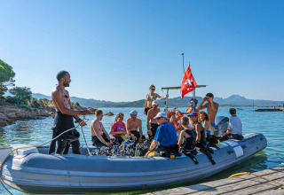 Gruppo di persone su un gommone al Centro Vacanze Isuledda, Sardegna, Italia, pronto per immersioni.