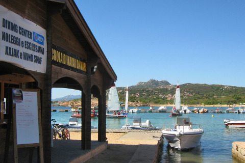 Barcos y veleros en el puerto del Centro Vacanze Isuledda en Cerdeña, Italia, en un día soleado.