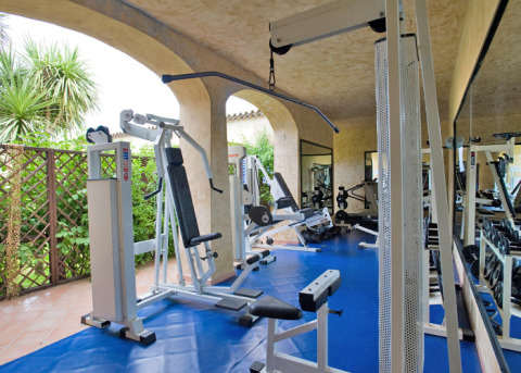 Sala de fitness con equipos modernos en Centro Vacanze Isuledda, parque vacacional en Cerdeña, Italia.