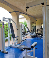 Sala de fitness con equipos modernos en Centro Vacanze Isuledda, parque vacacional en Cerdeña, Italia.