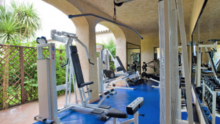 Sala de fitness con equipos modernos en Centro Vacanze Isuledda, parque vacacional en Cerdeña, Italia.