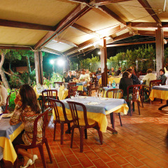 Cena al aire libre con huéspedes en Centro Vacanze Isuledda, un parque vacacional en Cerdeña, Italia.