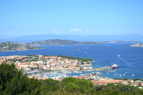 Zicht op Centro Vacanze Isuledda, vakantiepark met jachthaven en blauwe zee op Sardinië, Italië.