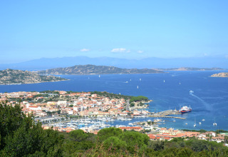 Zicht op Centro Vacanze Isuledda, vakantiepark met jachthaven en blauwe zee op Sardinië, Italië.
