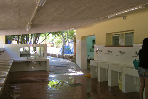 Wasruimte bij Centro Vacanze Isuledda vakantiepark op Sardinië, Italië, met wasbakken en spiegels.