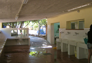 Vaskeområde i Centro Vacanze Isuledda feriepark på Sardinien, Italien, med håndvaske og spejle.