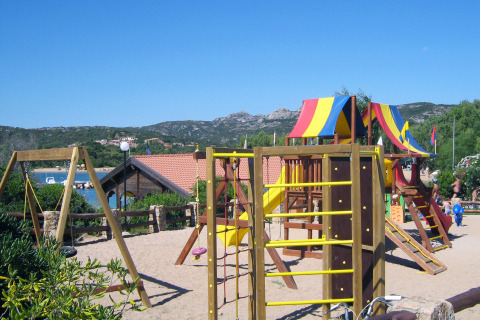 Parque infantil con juegos coloridos y toboganes en Centro Vacanze Isuledda, Cerdeña, Italia