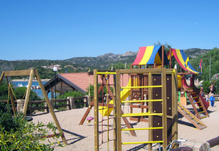 Speelplein met kleurrijke toestellen en glijbanen in Centro Vacanze Isuledda, Sardinië, Italië