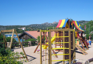 Legeplads med farverige legeredskaber og rutsjebane på Centro Vacanze Isuledda, Sardinien, Italien