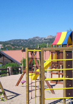 Parque infantil con juegos coloridos y toboganes en Centro Vacanze Isuledda, Cerdeña, Italia