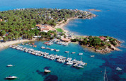 Vista aérea de Centro Vacanze Isuledda en Cerdeña, Italia, con puerto deportivo, playa y naturaleza verde.