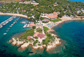 Luftfoto af Centro Vacanze Isuledda feriepark på Sardinien, Italien, med strande og bådhavn.