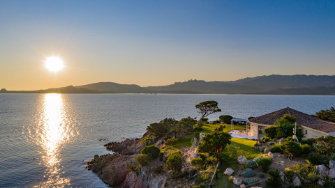Puesta de sol sobre el mar en Centro Vacanze Isuledda, parque vacacional en Cerdeña con vistas al litoral.
