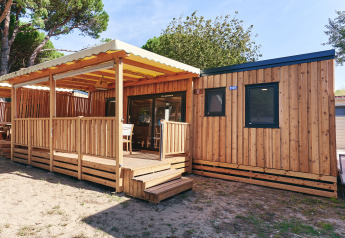 Vista esterna della SunLodge Babul al Centro Vacanze Isuledda, con veranda in legno coperta in Italia.