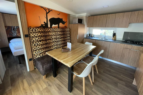 Cuisine et coin repas lumineux à SunLodge Babul, Centro Vacanze Isuledda en Italie, avec un décor safari.