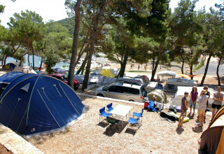 Camping Village Poljana in Croazia con tende, roulotte, persone e vista panoramica sul mare.