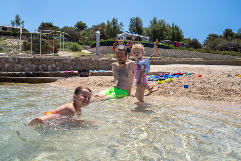 Famiglia si gode la giornata in spiaggia al Camping Village Poljana, Primorje-Gorski Kotar, Croazia.