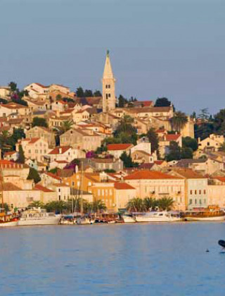 Vista panorámica de Mali Lošinj con casas coloridas y barcos en el agua en Primorje-Gorski Kotar, Croacia.