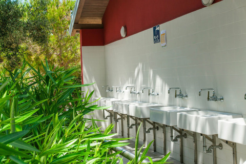 Outdoor washing area with multiple sinks and faucets at Camping Village Poljana in Primorje-Gorski Kotar, Croatia.