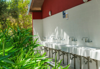 Outdoor washing area with multiple sinks and faucets at Camping Village Poljana in Primorje-Gorski Kotar, Croatia.