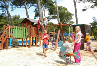 Kinderen spelen op de speeltuin in Camping Village Poljana, vakantiepark in Primorje-Gorski Kotar, Kroatië.