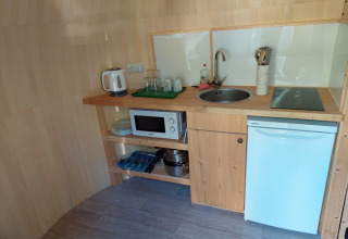 Kompakt køkken i IGLO Log Cabin ved Camping Emmen i Holland med vask, mikroovn og minikøleskab.