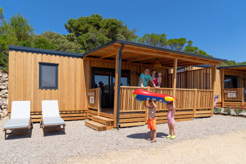 Familia disfrutando su estancia en SunLodge BigLeaf, Camping Village Poljana, Croacia, con niños jugando afuera.