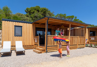 Familia disfrutando su estancia en SunLodge BigLeaf, Camping Village Poljana, Croacia, con niños jugando afuera.