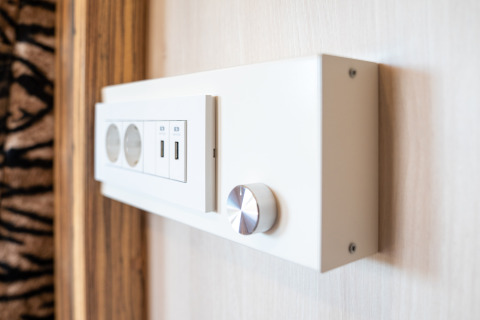 Stikkontaktpanel med stik og USB-porte på SunLodge BigLeaf, hotelindretning med moderne finish.