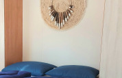 Modern bedroom at Beach House in Beloofde Land, Netherlands, with blue bedding and woven decor on the wall.