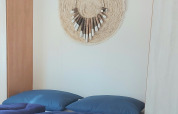 Modern bedroom at Beach House in Beloofde Land, Netherlands, with blue bedding and woven decor on the wall.