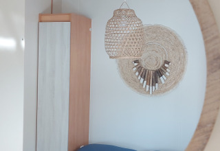 Riflessione allo specchio di una stanza accogliente al Beach House di Beloofde Land, Paesi Bassi, con cuscini blu.