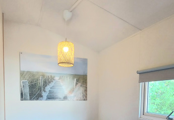 Lyst værelse i Beach House, Beloofde Land, Holland, med to senge, blå sengetøj og vindue.