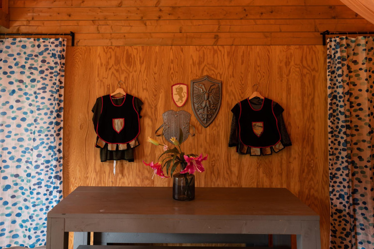 Decorazione a tema cavaliere e principessa con costumi medievali, scudi e fiori in una tenda safari a Beloofde Land.